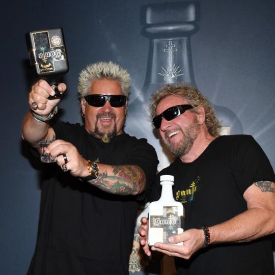 Emmy Award-winning chef and television personality Guy Fieri (L) and Rock & Roll Hall of Fame inductee Sammy Hagar announce their partnership with Los Santo and Santo Puro Mezquila, in addition to the launch of Santo Fino Tequila at Southern Glazer's Wine & Spirits of Nevada on April 4, 2019 in Las Vegas, Nevada. (Photo by Ethan Miller/Getty Images for Los Santos: Santo Puro Mezquila)
