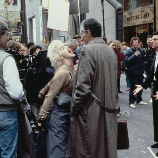 American singer and actress Madonna on the set of the film 'Slammer', later titled 'Who's That Girl?', USA, 1987. Her co-star Griffin Dunne is in tails on the right. (Photo by Vinnie Zuffante/Michael Ochs Archives/Getty Images)